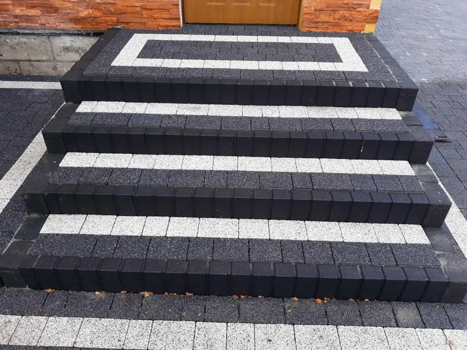 Schody z czarnej kostki z jasnymi stopnicami przed wejściem